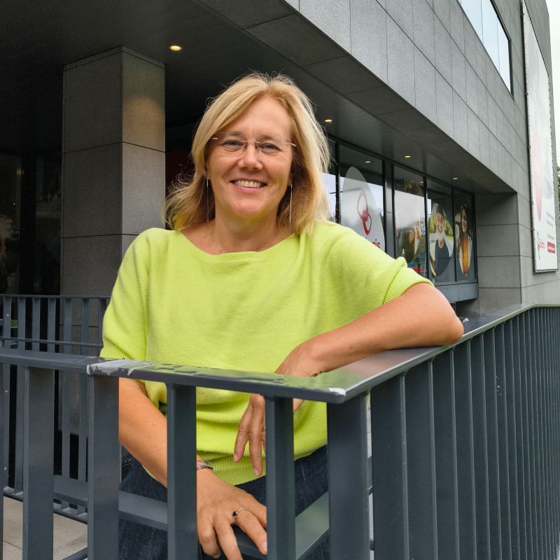 Vrouw staat naast een trap buiten een kantoor