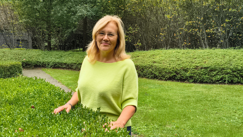 Vrouw staat in groene tuin